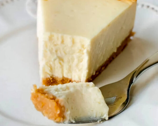 Cheesecake slice, fork with piece of the cheesecake