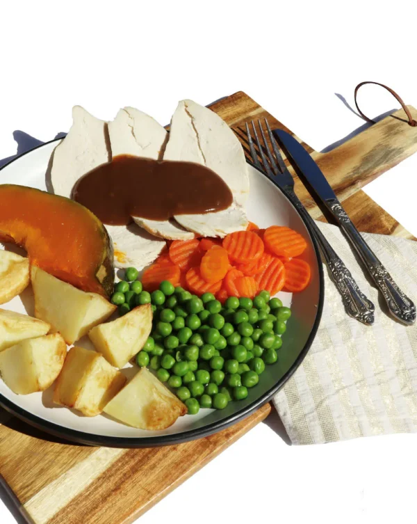 Roast chicken slices with gravy, roast pumpkin and potato, peas and carrots