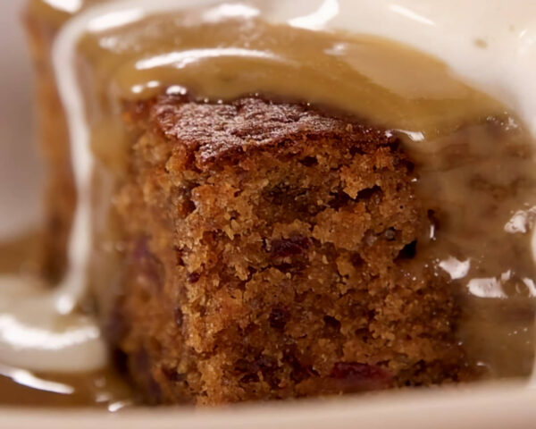 Sticky date pudding with butterscotch sauce running off the sides