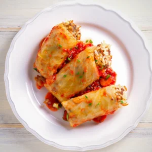 Three stuffed cabbage rolls, filled with mince and rice with a tomato sauce