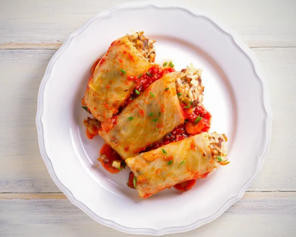 Three stuffed cabbage rolls, filled with mince and rice with a tomato sauce